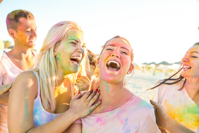friends laughing with colored dust on them